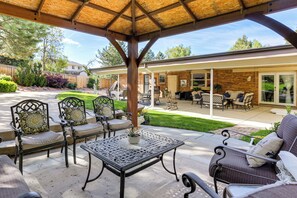 Une terrasse extérieure dotée d’une pergola, d’un espace salon et offrant une vue sur le jardin arrière.