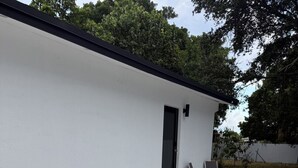 Un bâtiment moderne doté d’un toit plat, d’une terrasse en béton et d’une porte.