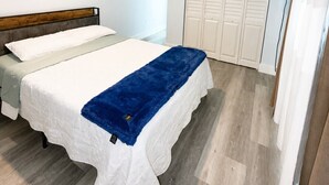 Una camera da letto con un letto, un armadio, una TV e una luce a soffitto.
