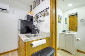 A compact kitchen with a built-in refrigerator, a coffee maker, a sink, and a roll of toilet paper. - Retreat for Couples & Artists! Atlanta Tiny Home (Atlanta)