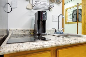 A kitchen with a coffee maker, a sink, and a window with blinds. - Retreat for Couples & Artists! Atlanta Tiny Home (Atlanta)