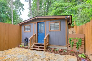 A small wooden cabin with a blue door, a wooden staircase, and a garden area with stepping stones and plants. - Retreat for Couples & Artists! Atlanta Tiny Home (Atlanta)
