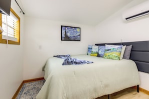 A bedroom with a bed, a painting, and an air conditioner. - Retreat for Couples & Artists! Atlanta Tiny Home (Atlanta)
