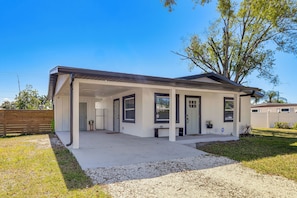 A modern single-story house with a covered porch, a fenced yard, and a large tree. - Work & Play in Palmetto! Pet-friendly Home w/ Yard (Palmetto)