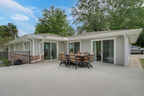 A house with a patio, a dining table with chairs, and a garage.