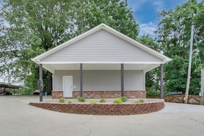 A single-story house with a covered porch, a brick foundation, and a garage door.