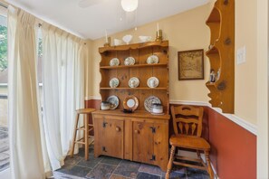 Un meuble en bois avec des étagères, une chaise et une fenêtre avec des rideaux.