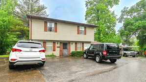 A two-story house with a garage, parked cars, and a driveway. - Bring Your Pets! Walkable Retreat in Manchester (Manchester)