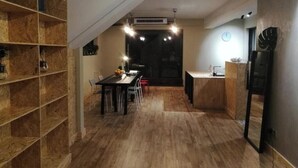 Une cuisine moderne avec un coin repas, un plancher en bois, des étagères intégrées et un système de climatisation central.