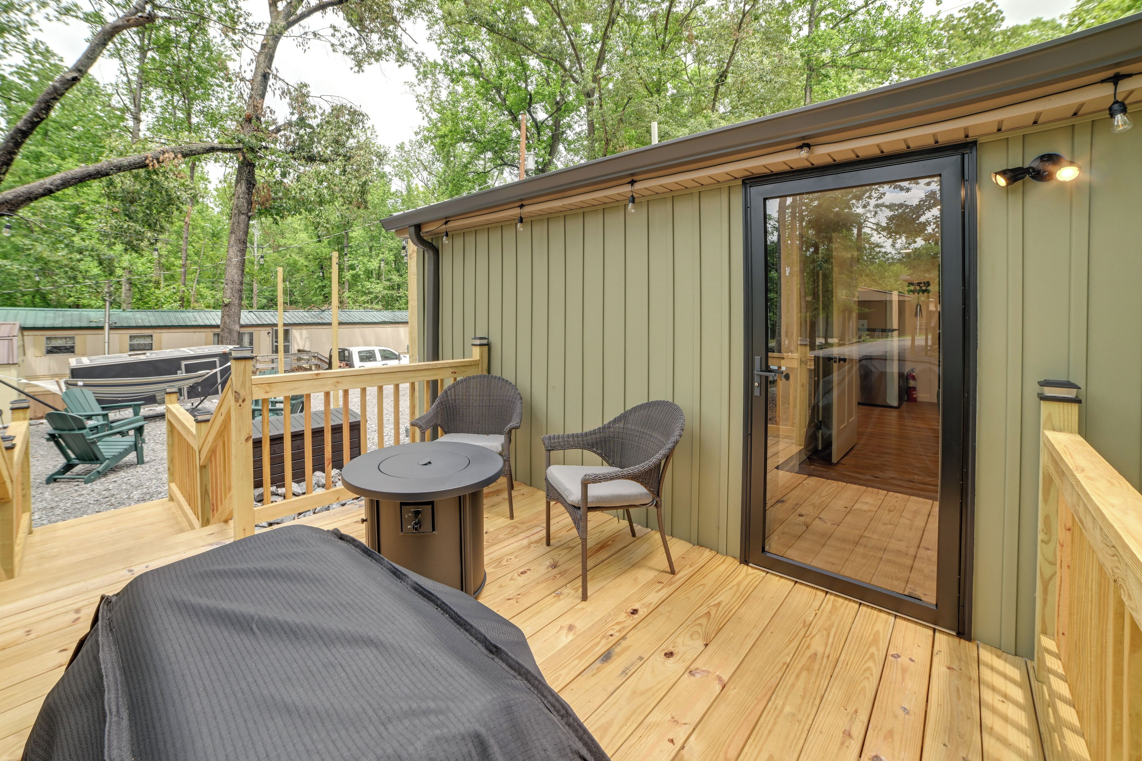 A deck with a grill, chairs, and a table.