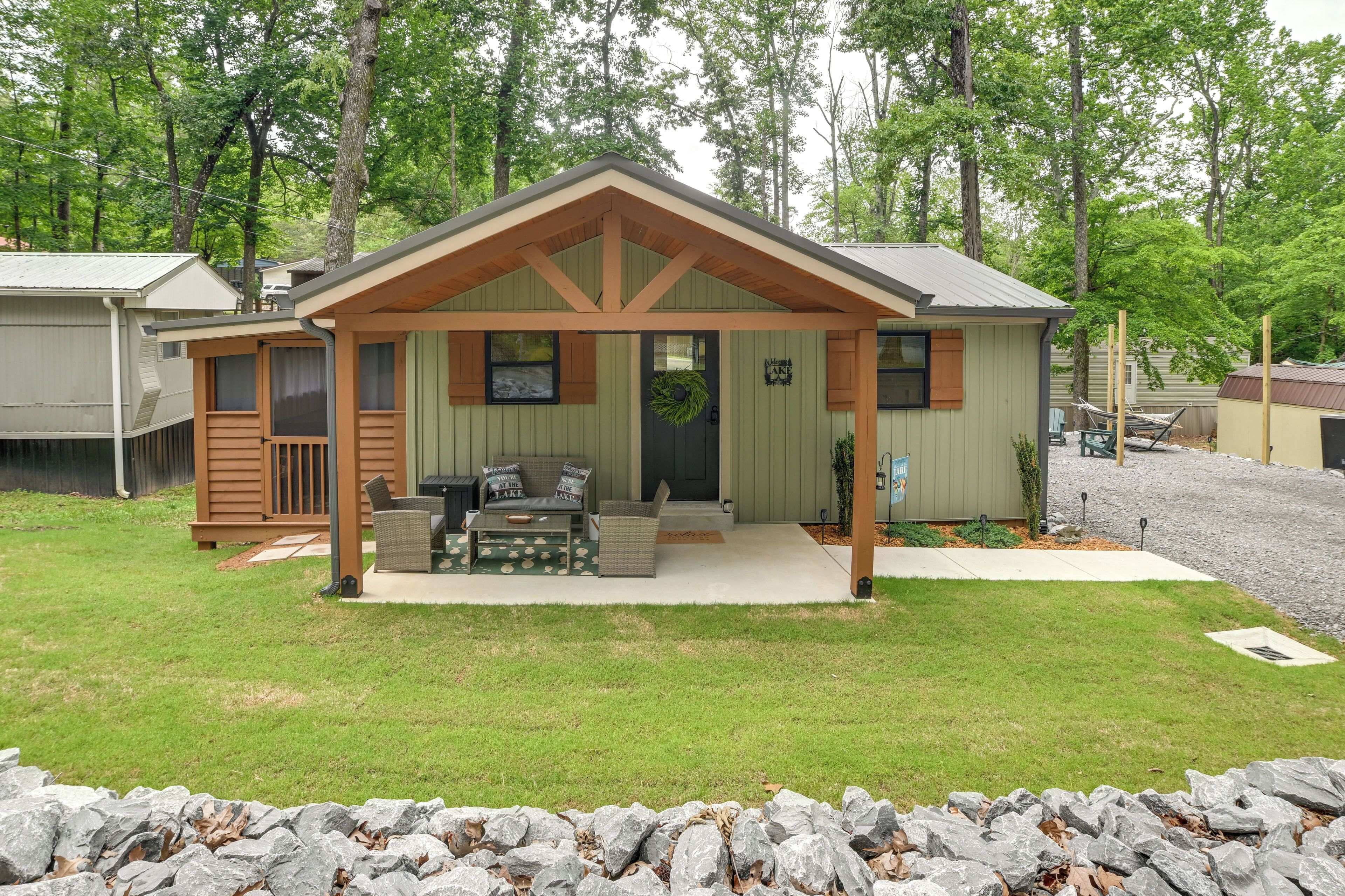 A small cabin with a porch, a grill, and a wreath on the door.