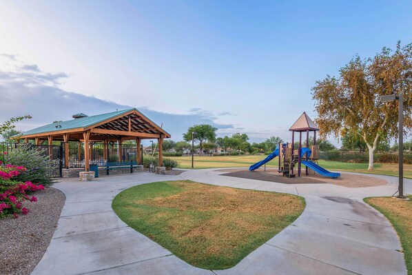 A park with a pavilion, playground, and a clear sky.