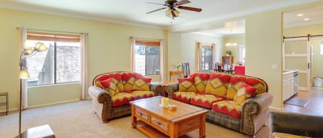 A living room with a sofa, coffee table, and a ceiling fan.