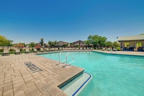 A clear blue swimming pool with a brick deck, lounge chairs, and a covered seating area. - San Tan Valley Home w/ Patio in Johnson Ranch! (San Tan Valley)
