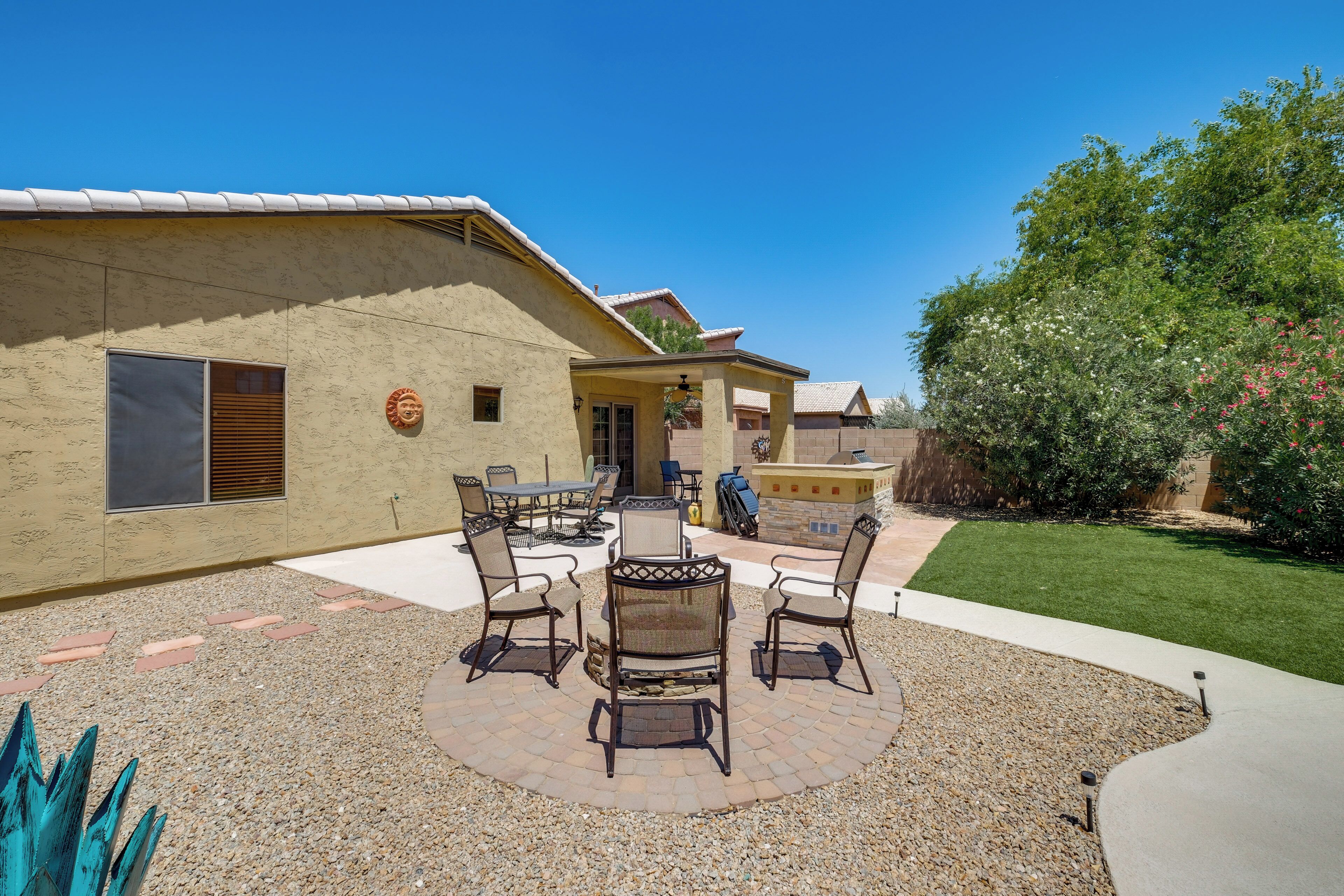 A patio with outdoor furniture, a covered seating area, and a well-maintained lawn.