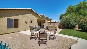 A patio with outdoor furniture, a covered seating area, and a well-maintained lawn.