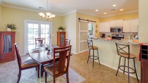 A kitchen with a dining area, a chandelier, and a view of the outdoors. - San Tan Valley Home w/ Patio in Johnson Ranch! (San Tan Valley)