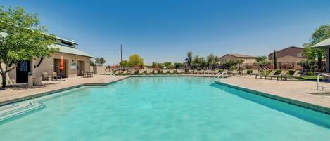 A swimming pool with a 3ft no diving sign, lounge chairs, and a clear blue sky.