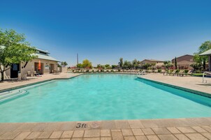 Una piscina con un cartel que indica ‘no saltos’ (aproximadamente 90 centímetros), sillas de descanso y un cielo azul despejado.