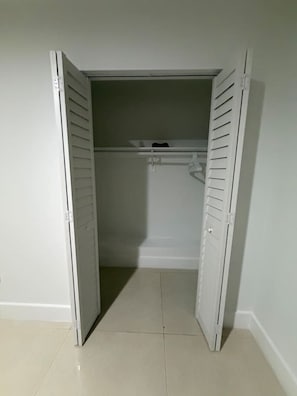 Ein Schrank mit weißen Schiebetüren und einem gefliesten Boden.