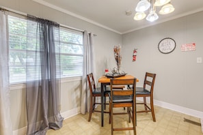 A dining area with a table, chairs, a vase, and a 'No Smoking' sign on the wall.