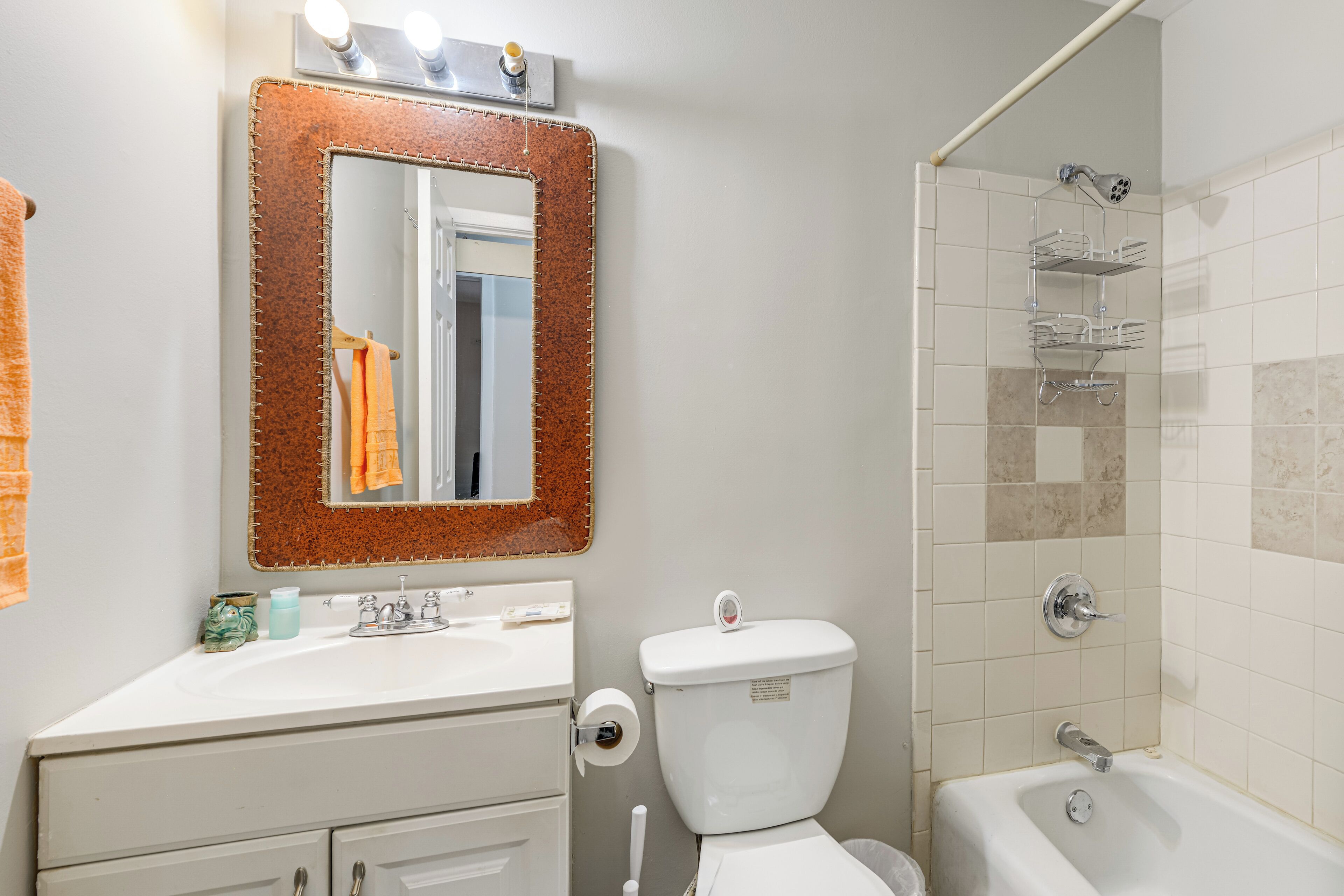 Une salle de bain équipée d’un lavabo, d’un miroir, de toilettes et d’une douche.