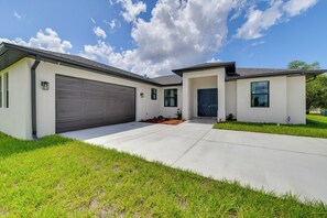 Ein modernes, zweistöckiges Haus mit Garage, Veranda und gepflegtem Rasen.