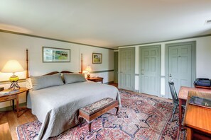 A bedroom with a bed, bedside tables, a bench, a rug, and two doors. - Private, Exclusive, Colonial Pocomoke River Estate (Pocomoke City)