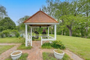 A gazebo with a tiled roof, two swings, and a brick pathway leading to it. - Private, Exclusive, Colonial Pocomoke River Estate (Pocomoke City)