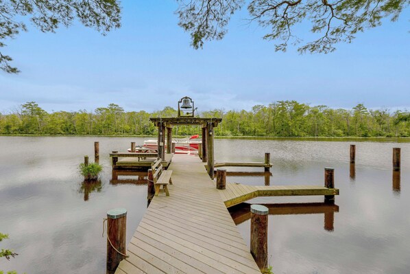 A wooden pier extending into calm water, with a bench and a lamp post at the end. - Private, Exclusive, Colonial Pocomoke River Estate (Pocomoke City)