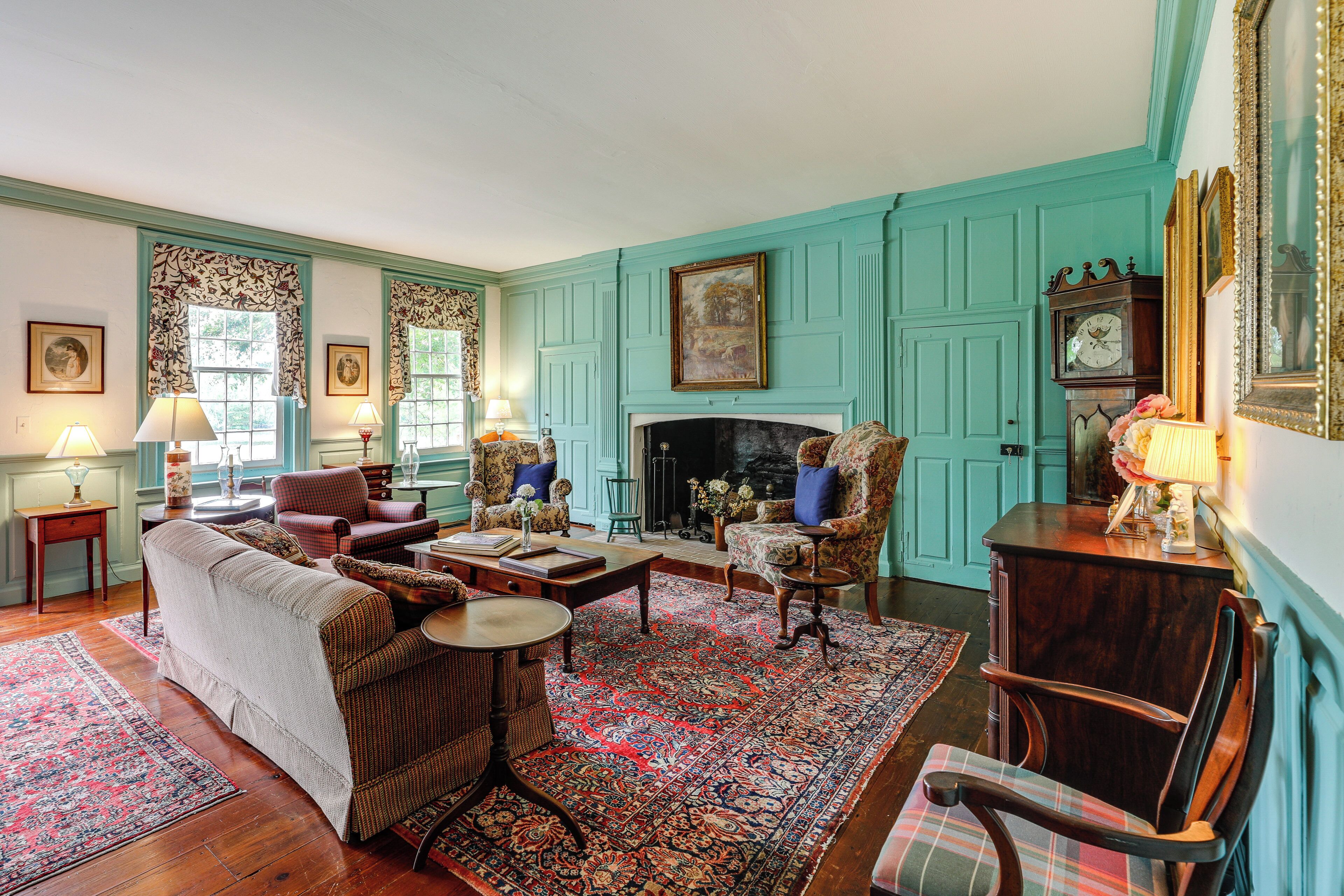 A traditional living room with a fireplace, patterned rugs, and classic furniture.