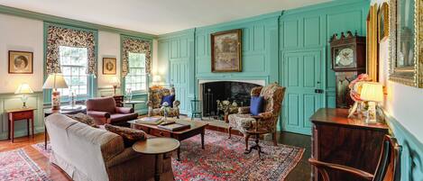 A traditional living room with a fireplace, patterned rugs, and classic furniture.