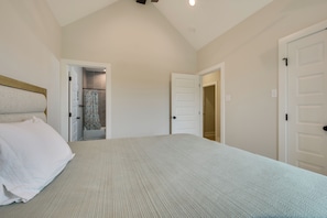 Un dormitorio con cama, puerta y zona de ducha.
