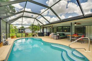 A covered swimming pool with a glass ceiling, a lounge area with furniture, and a view of the outdoors. - Heated Pool & Resort-style Perks! Punta Gorda Home (Punta Gorda)