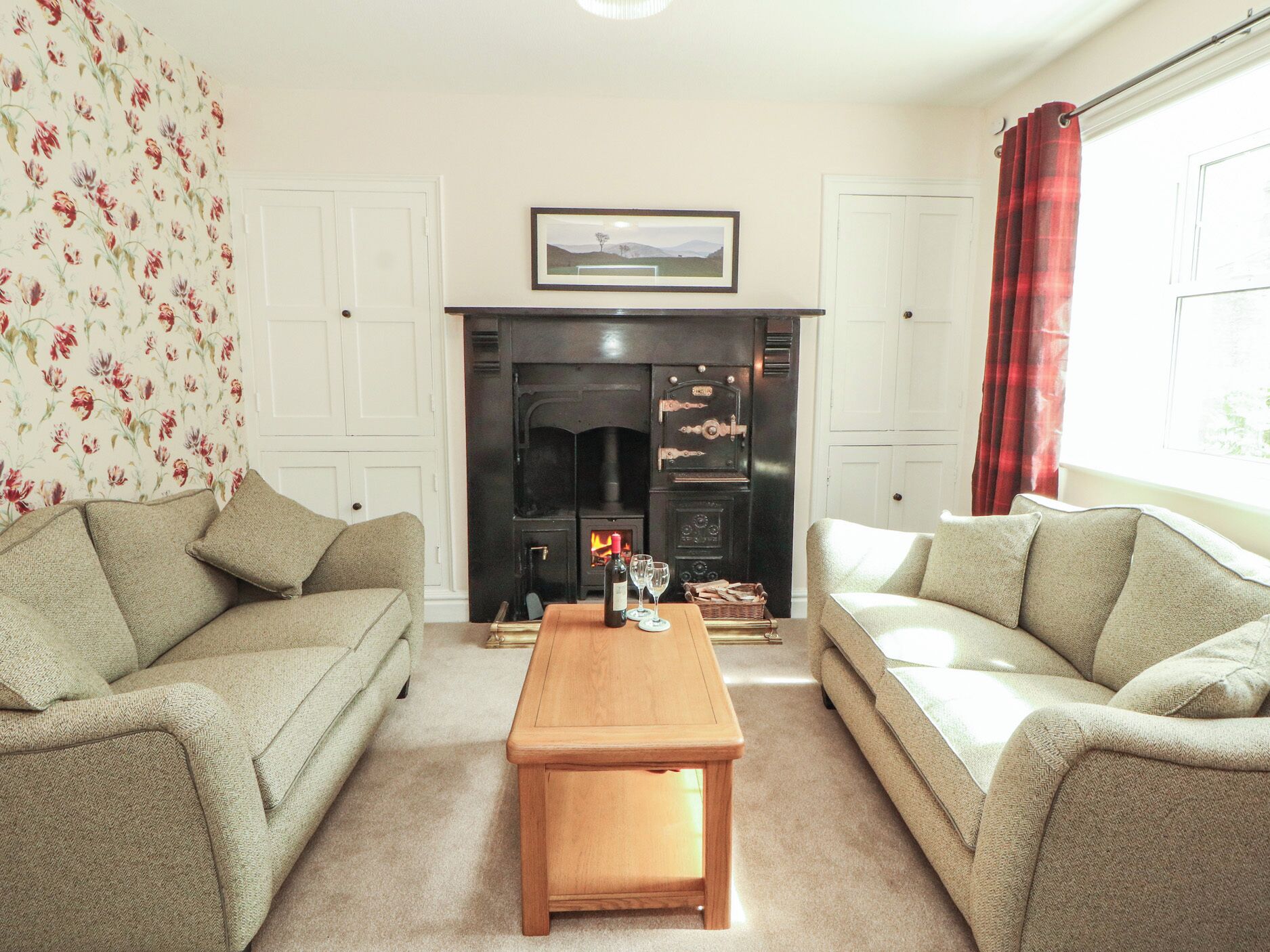 A living room with two sofas, a wooden coffee table, a fireplace, and a framed picture above it.