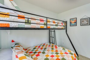 A bunk bed with a colorful quilt, a ladder, and a vacuum hose. - Walk to Lake Huron Beach Access! Family Getaway (East Tawas)
