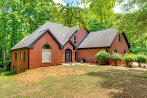 A brick house with a gabled roof, a front entrance, and a small front yard with trees. - Harps Lake Family Retreat on 3 Private Acres (Ellenwood)