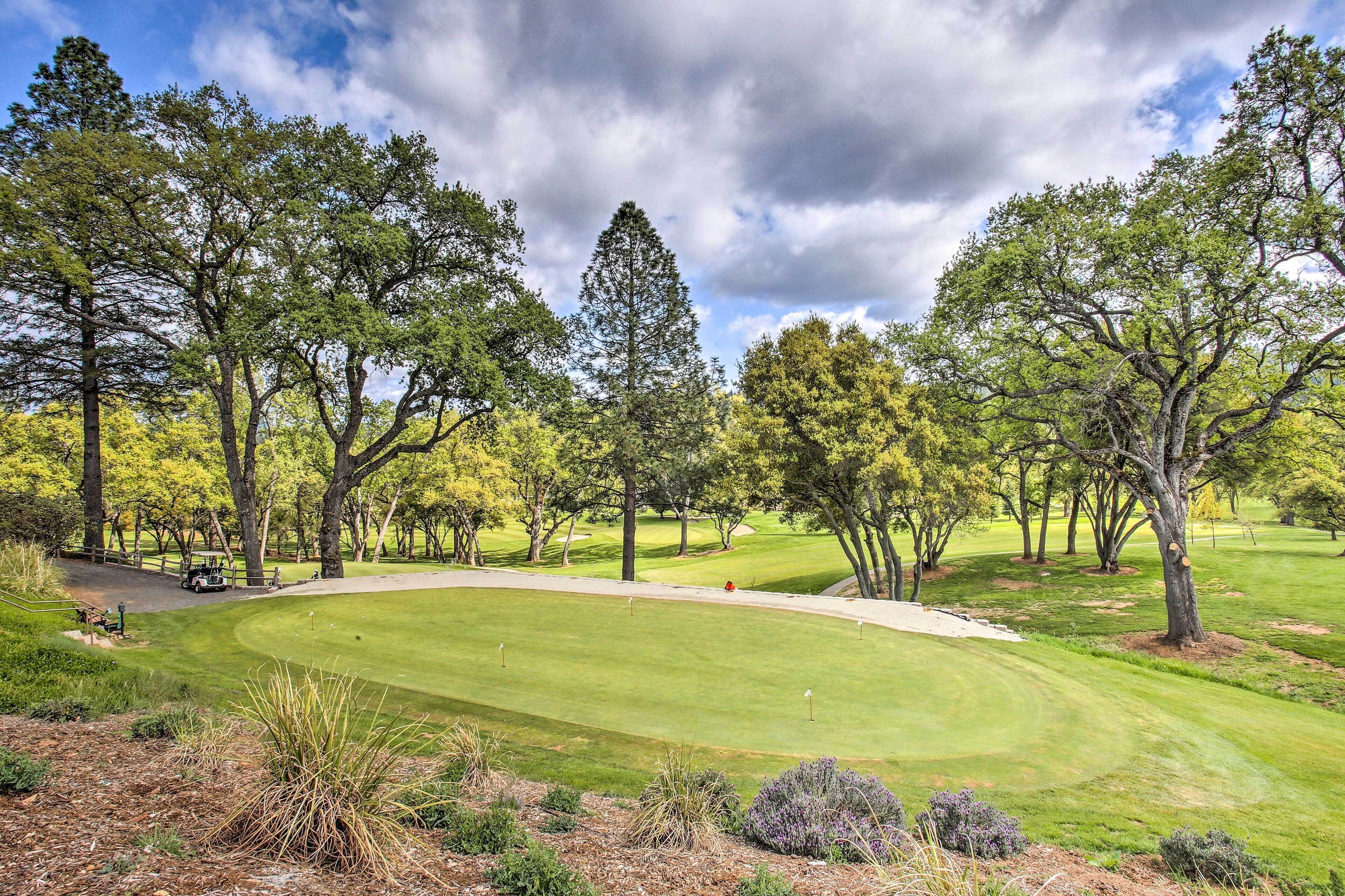 A golf course with a well-maintained fairway, sand bunkers, and a putting green.