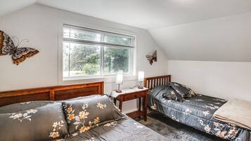 Un dormitorio con dos camas, una ventana y mariposas decorativas.