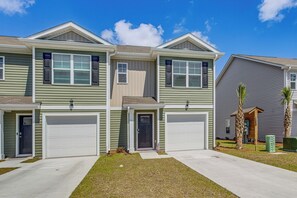 A two-story residential building with a garage, a front door, and a small porch. - 2 Mi to Sea & Sand! Modern New Build in Surfside (Surfside Beach)