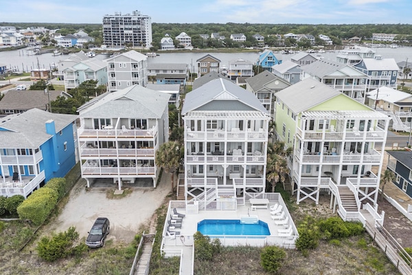 Elevated view of the vacation property showing its prime waterfront location, private pool, and proximity to the marina and surrounding coastal community.