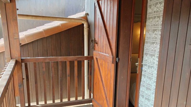 A wooden balcony with a wooden gate, a view of the interior, and a patterned window. - L'ANCRE BLEU ENTRE FILET ET MAREE; HOUSE IN THE HEART OF CAPBRETON HARBOR (Capbreton)