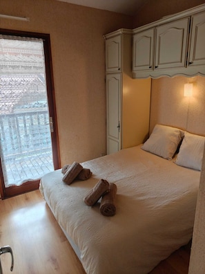 Ein Schlafzimmer mit einem Bett, zwei gerollten Handtüchern, einem Kleiderschrank und einem Fenster mit Blick.