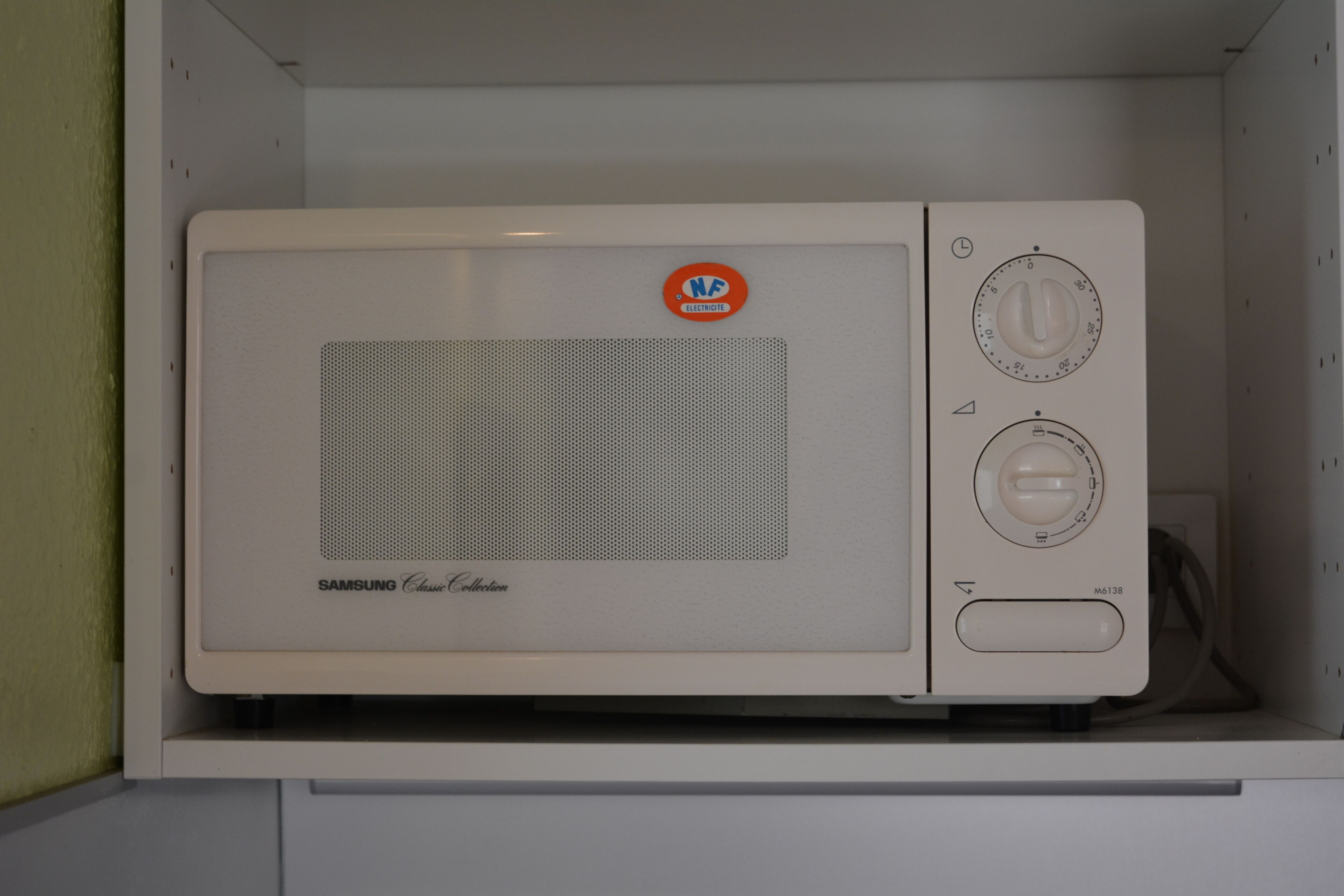 Eine weiße Mikrowelle in einem Küchenschrank.