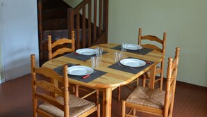 A dining table with six chairs, a clock on the wall, and a staircase in the background. - L'ANCRE BLEU ENTRE FILET ET MAREE; HOUSE IN THE HEART OF CAPBRETON HARBOR (Capbreton)