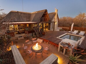 A modern house with a pool, outdoor seating, and a fire pit. - Ntoma House (Hoedspruit)