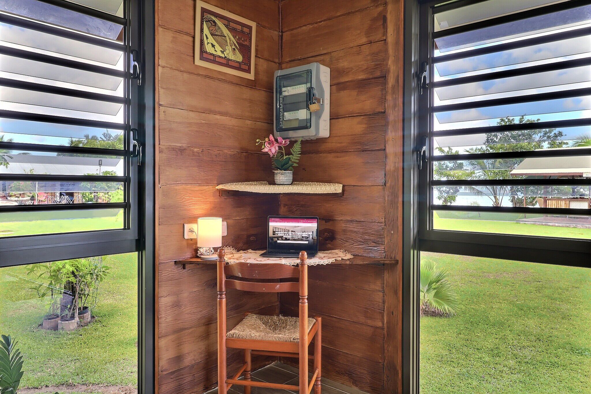 A wooden room with a desk, chair, and a laptop.