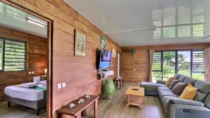 Un interno in legno con un letto, un divano, una TV e un tavolino.