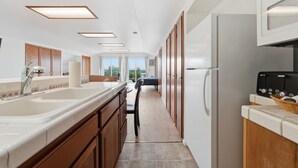 Eine Küche mit einer großen Kochinsel, Holzschränken und einem Kühlschrank.