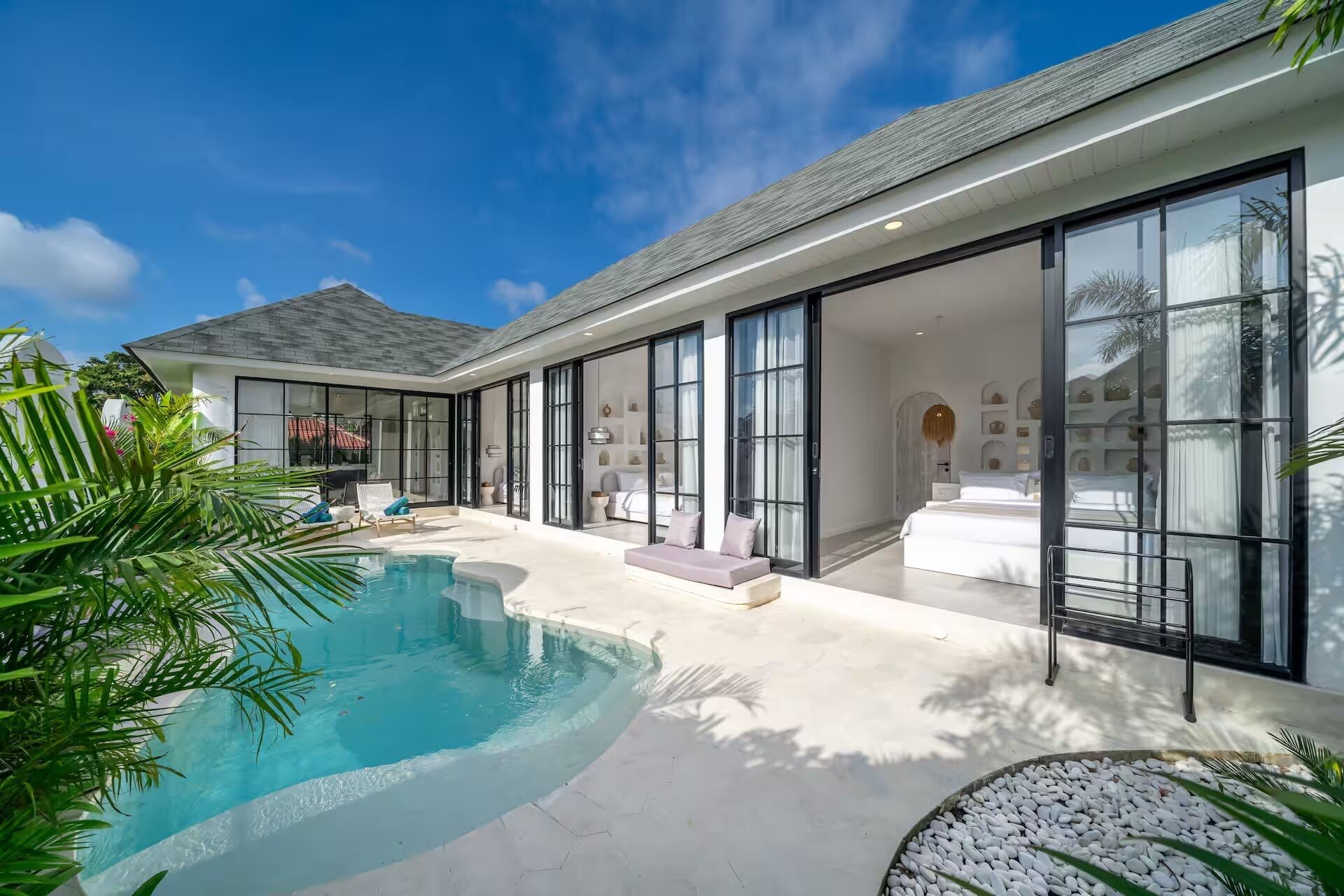 A modern house with a swimming pool, large glass doors, and a well-maintained garden.